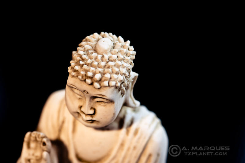Buddha I - High-key photo of a small Buddha statuette, with focus on face. High point of view.